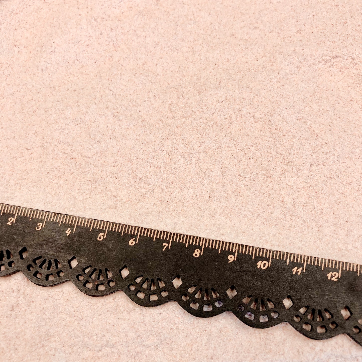 Crushed Mano de lion shell powder with a black metric ruler for scale. Also, known as "paw of the lion", this shell powder is uniform in size (less than 0.25mm). Great for inlay and beach projects.
