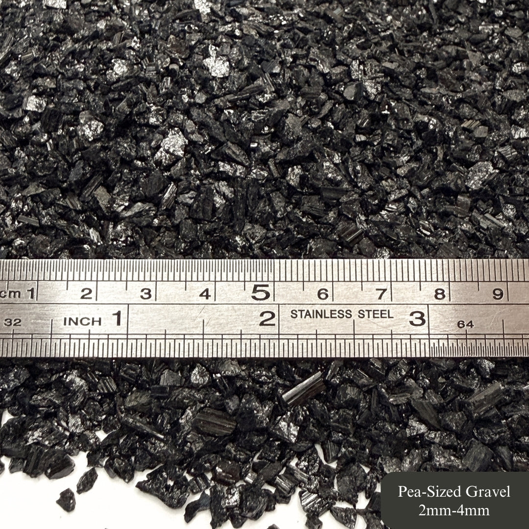 Rough tourmaline chips with a ruler showing measurements in millimeters and inches.