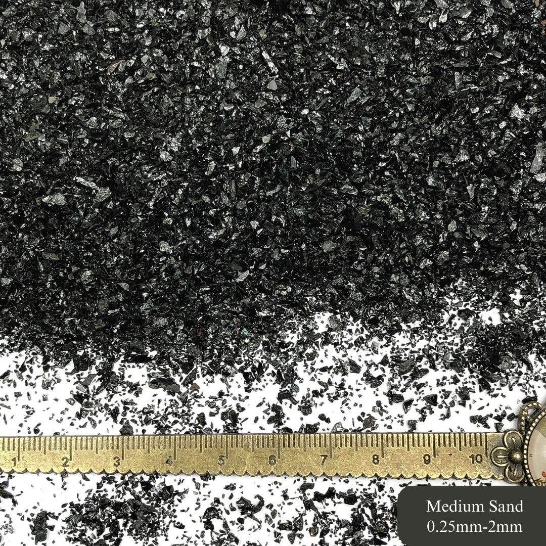 Crushed tourmaline sand with a metric ruler showing size.